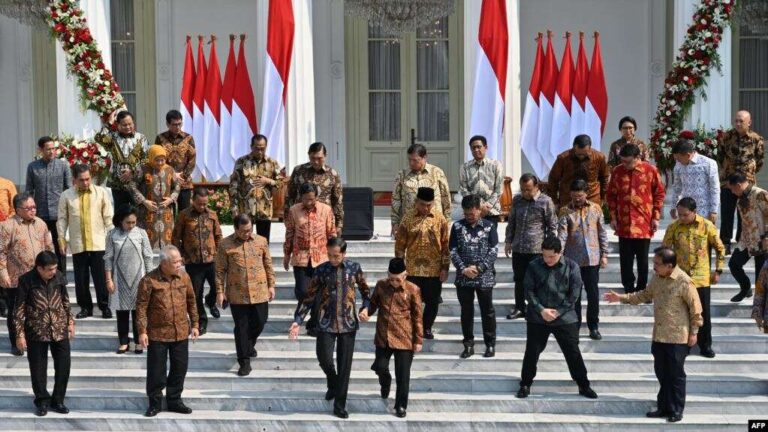 Perang "Radikalisme" di Kabinet Baru 3 Presiden Joko Widodo tengah kiri dan Wakil Presiden Maruf Amin tengah kanan bergandengan sebelum sesi foto dengan anggota kabinet baru di tangga Istana Merdeka