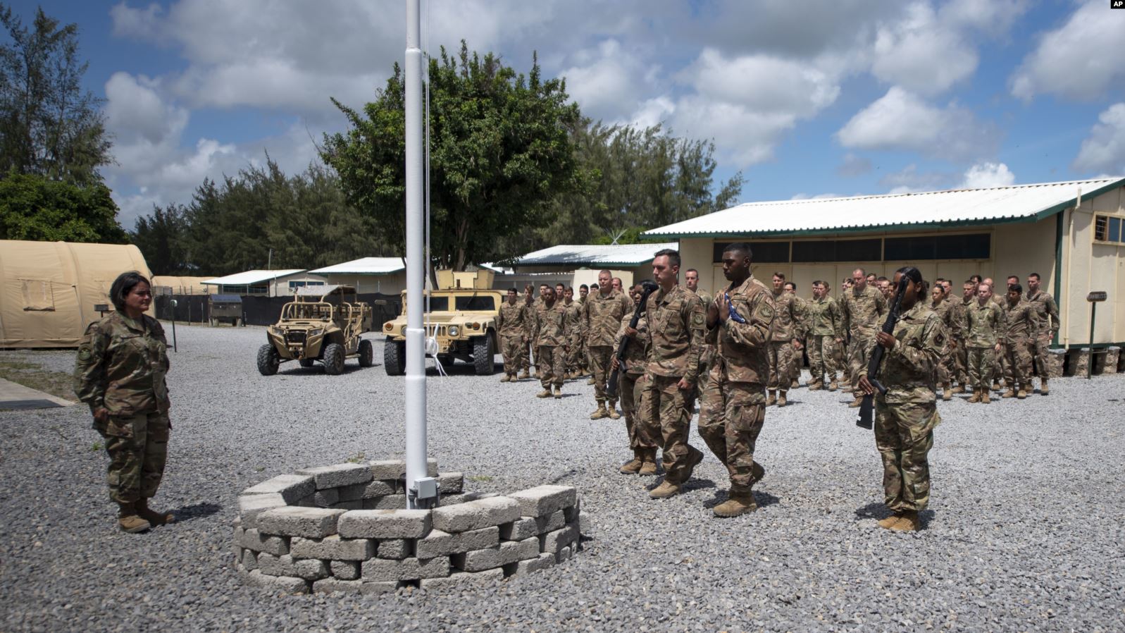 Para pilot dari Skuadron 475th mengikuti upacara bendera di Kamp Simba
