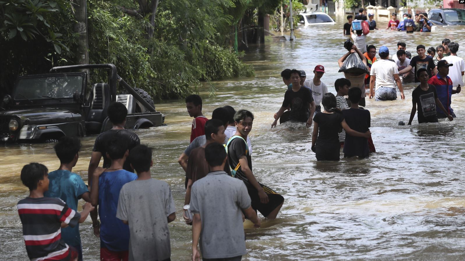 Warga berjalan mengarungi banjir di Tanggerang