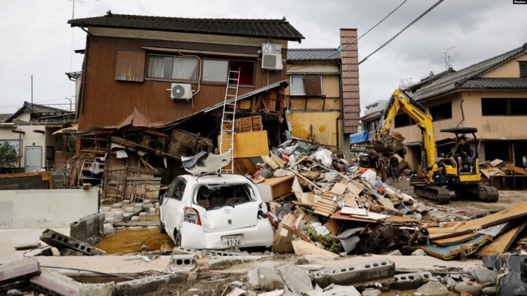 Ekskavator membersihkan puing puing di sebelah rumah yang hancur akibat banjir yang dipicu hujan lebat di Hitoyoshi Prefektur Kumamoto Jepang barat daya