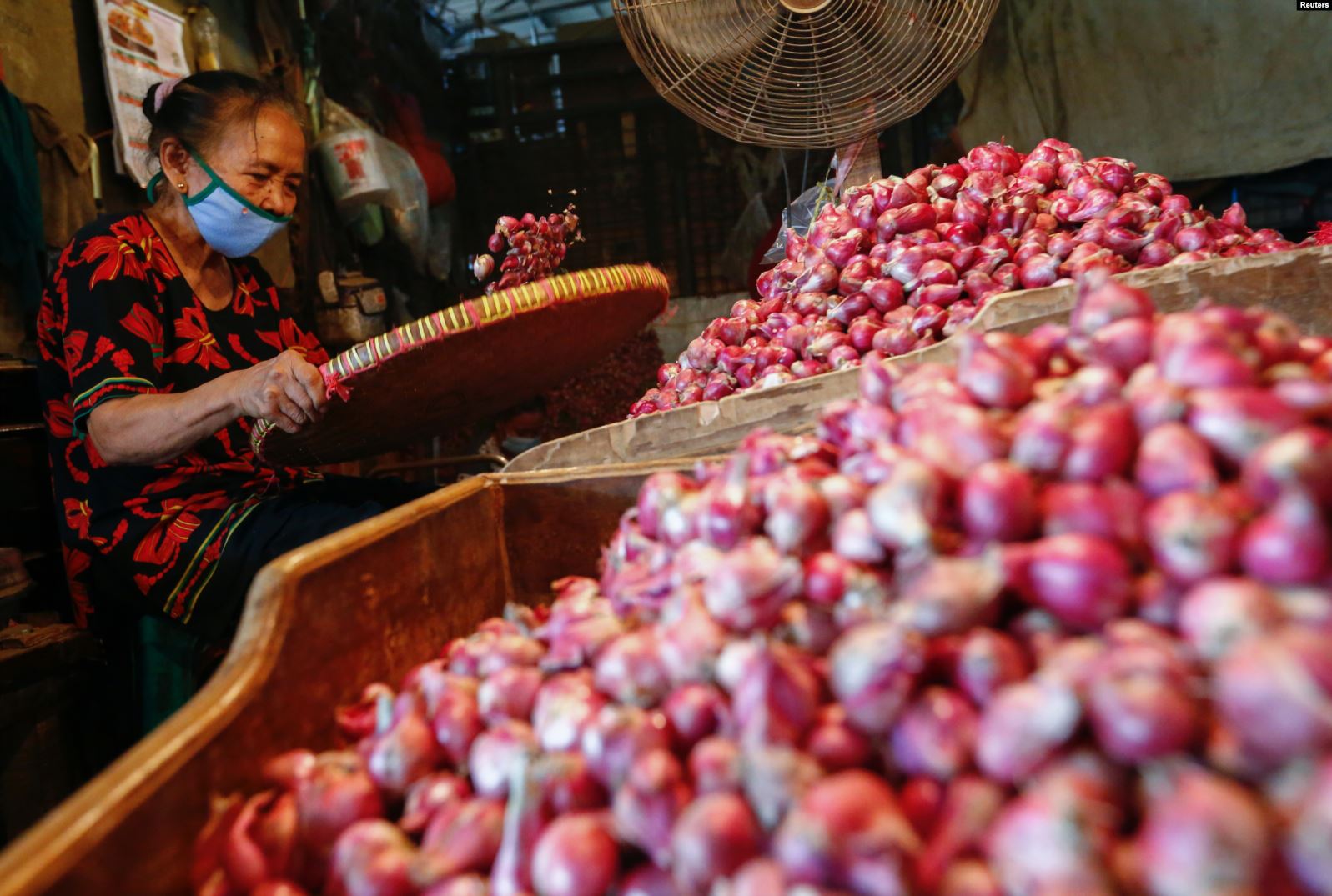 PSBB Ketat Mulai 14 September, Dilarang Kerumunan Lebih dari Lima Orang 5 Seorang pekerja mengenakan masker wajah memilah bawang di pasar tradisional di tengah pandemi virus corona
