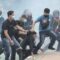 Polisi menahan para demonstran di tengah asap gas air mata dalam aksi yang berakhir rusuh di Jakarta
