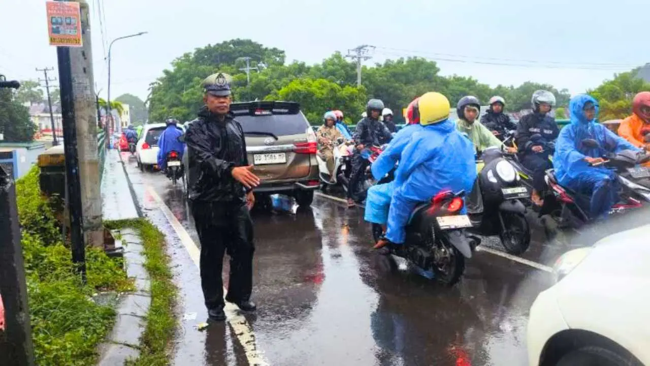 Guyuran Hujan Tak Halangi Polantas Tamalate Beri Pelayanan di Jalan