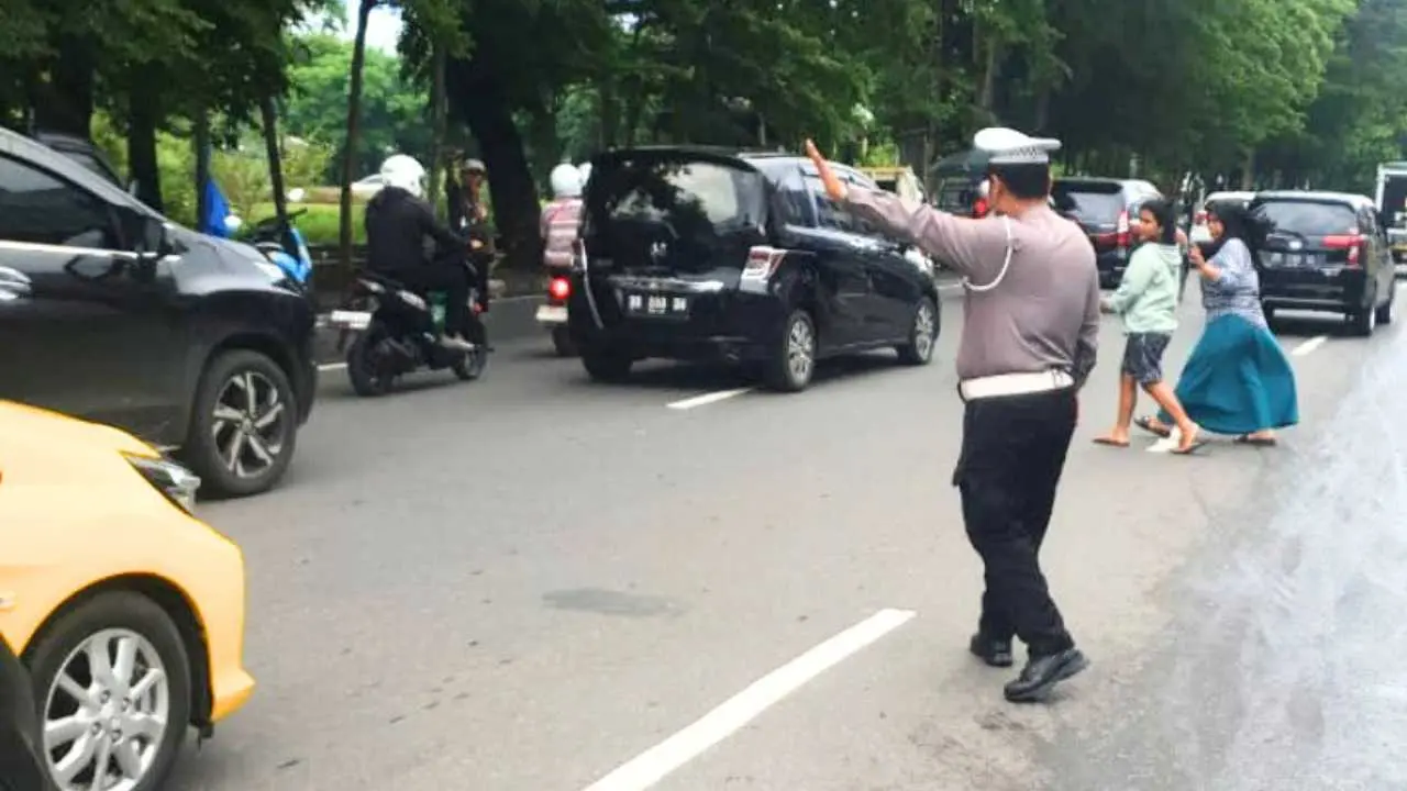 Aksi Humanis Polisi Lalu Lintas Bontoala: Bantu Warga Menyeberang Jalan di Pasar Terong