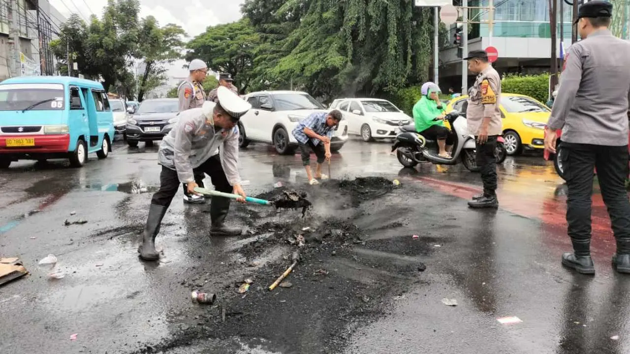 Polisi Bersihkan Bekas Bakar Ban Usai Unjuk Rasa